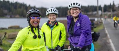 Three riders gather near the water for a quick photo.